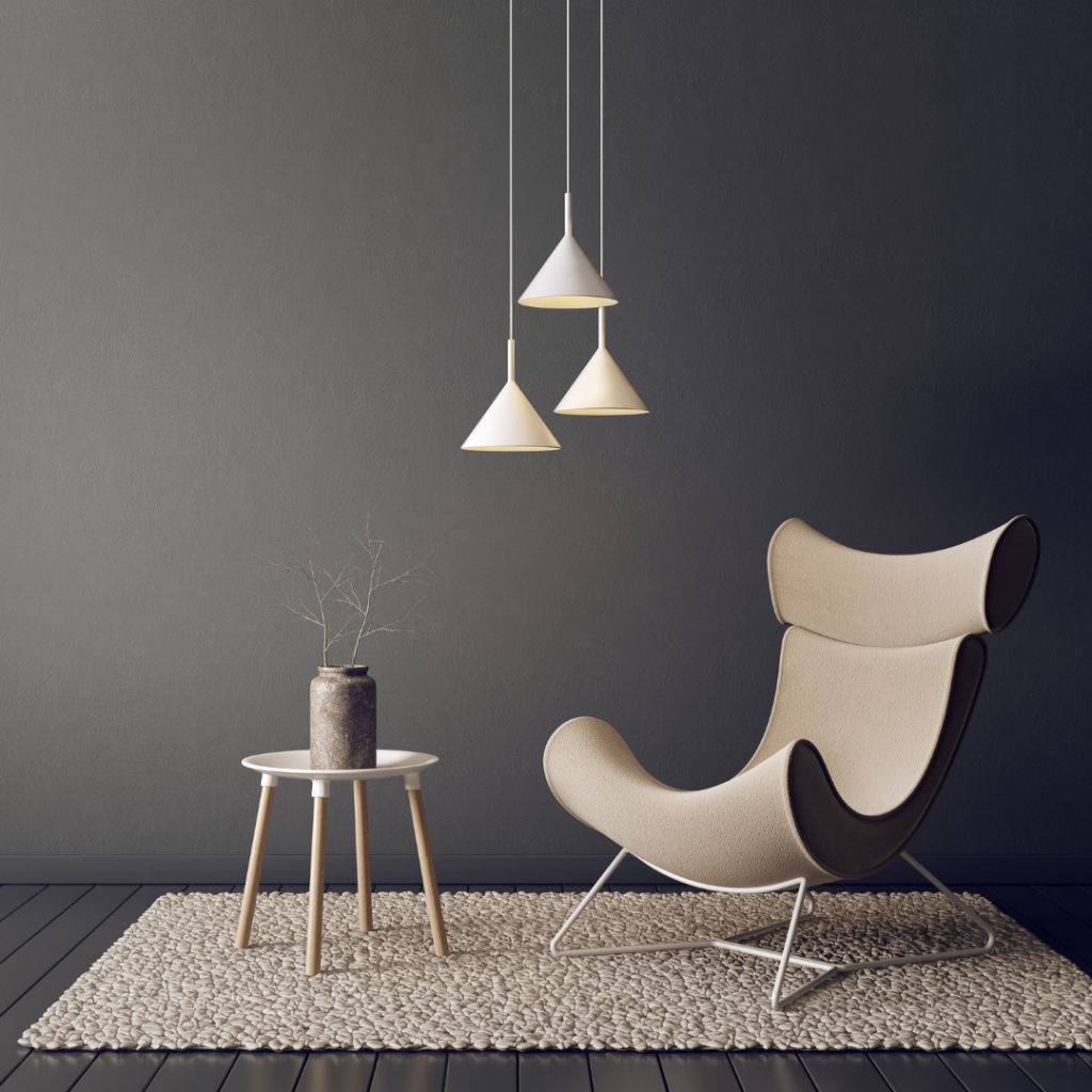 Minimalistyczne wnętrze z jasnym, designerskim fotelami, wiszącymi białymi lampami i stolikiem kawowym na grubym dywanie.